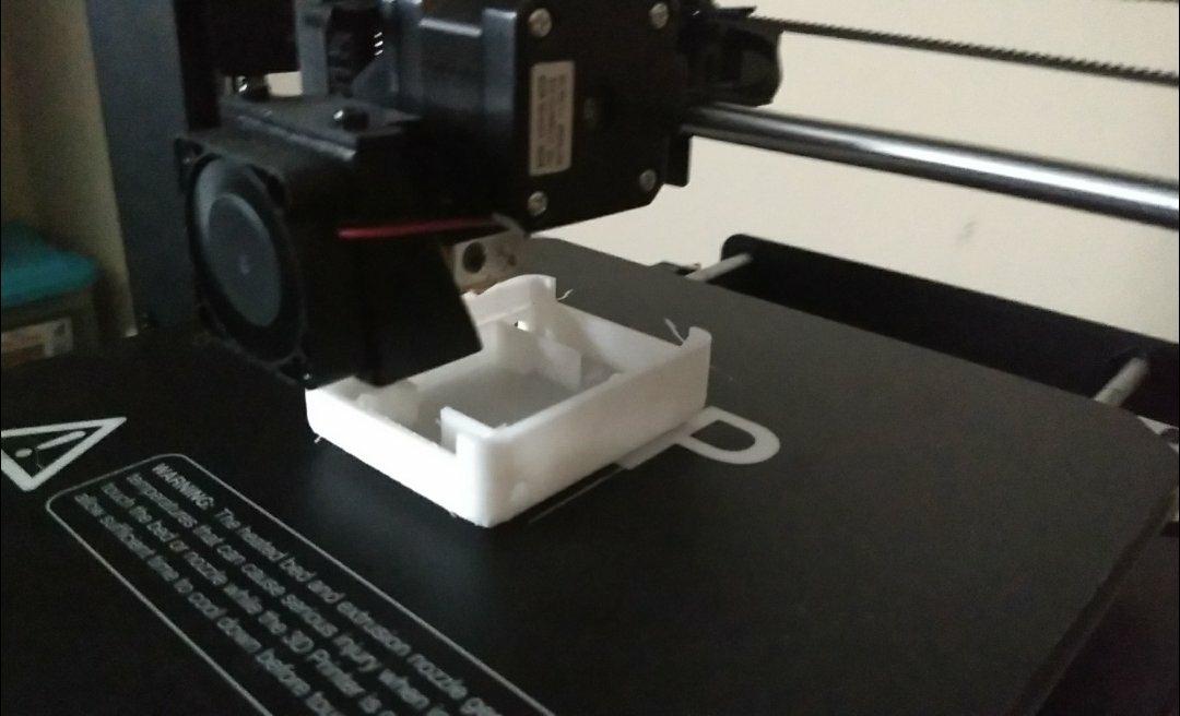 A 3d printer generating a small, square robot chassis.